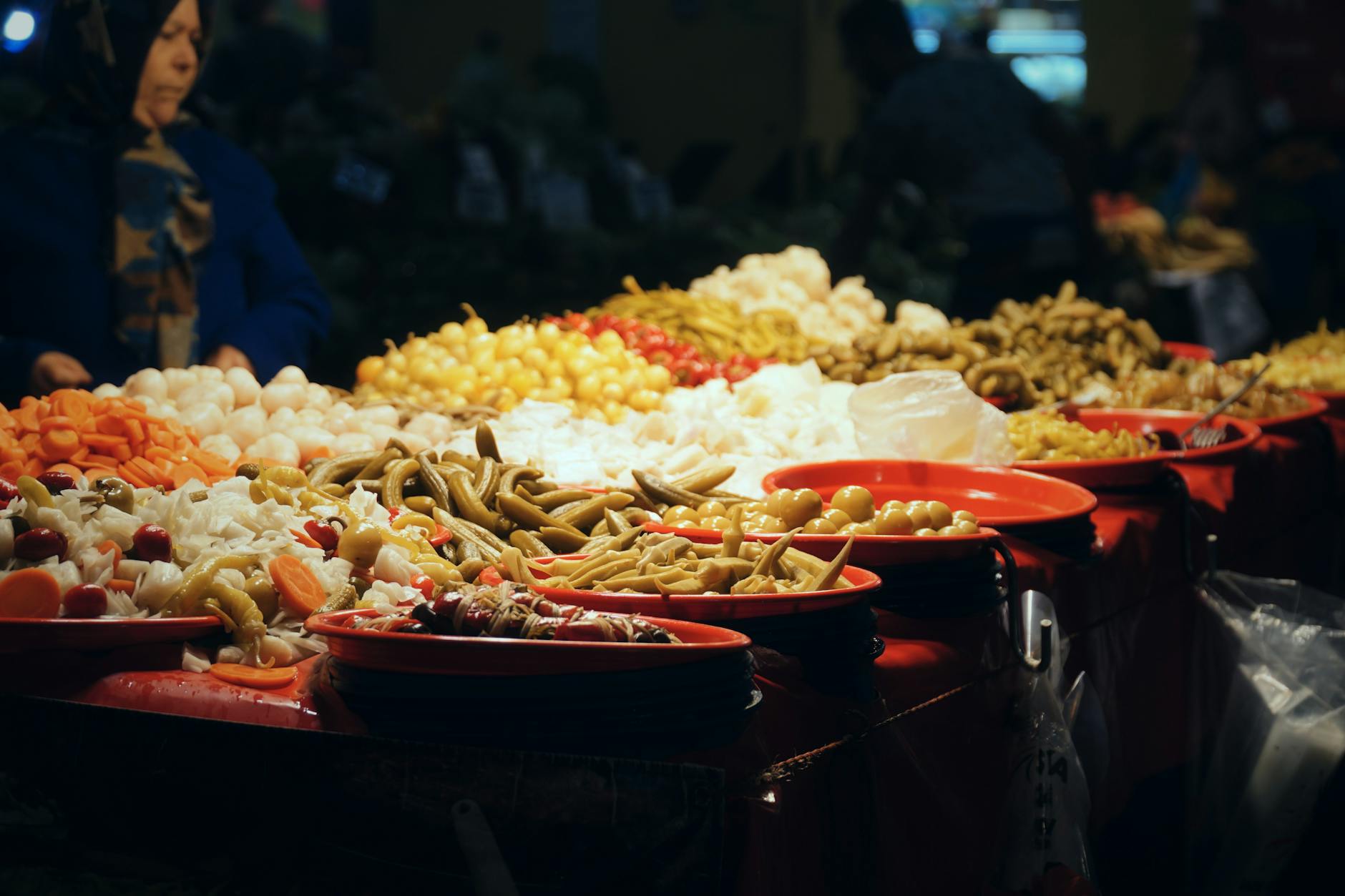 Vibrant assortment of pickles on display at an indoor market stall.