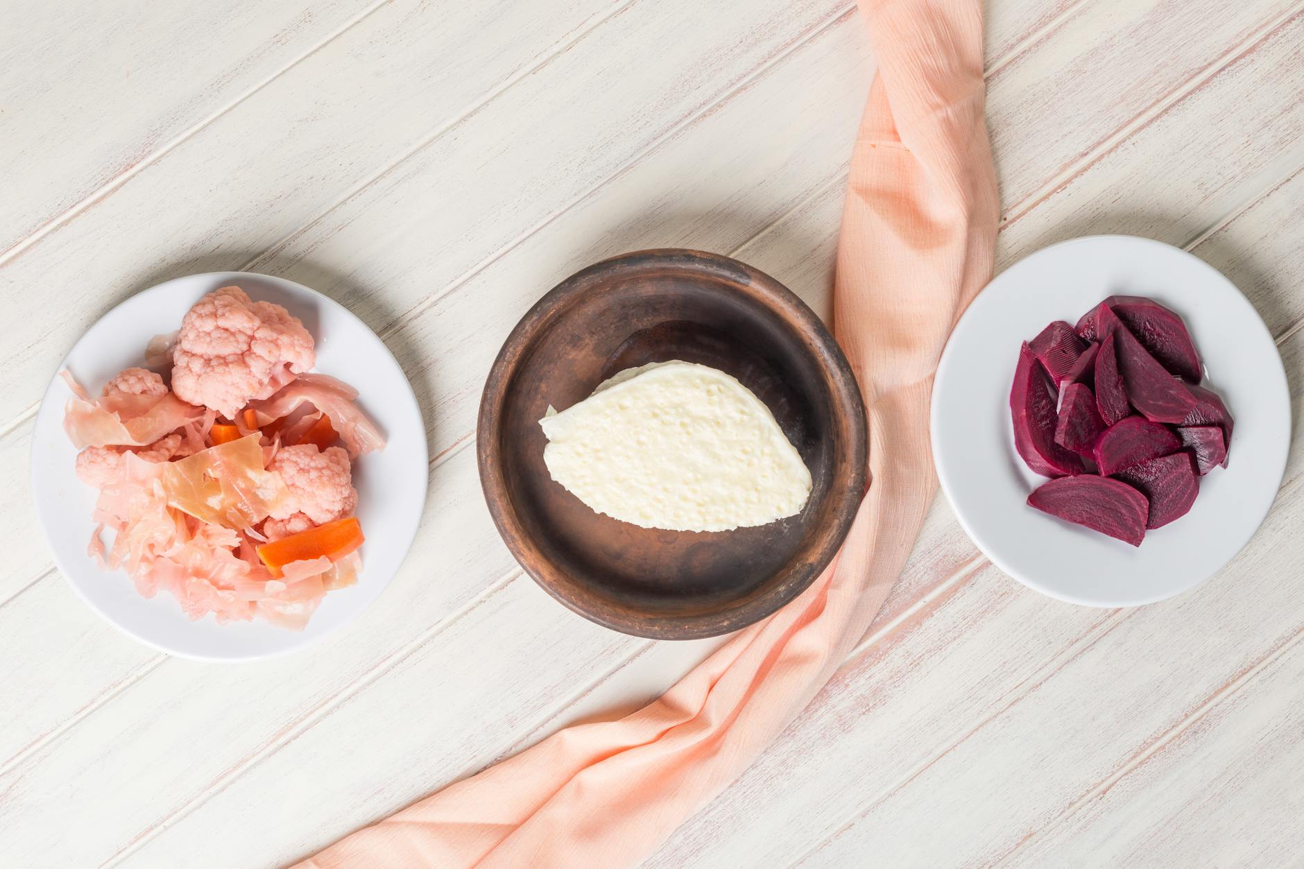 A flat lay of traditional Turkish meze plates featuring pickled vegetables and cheese.