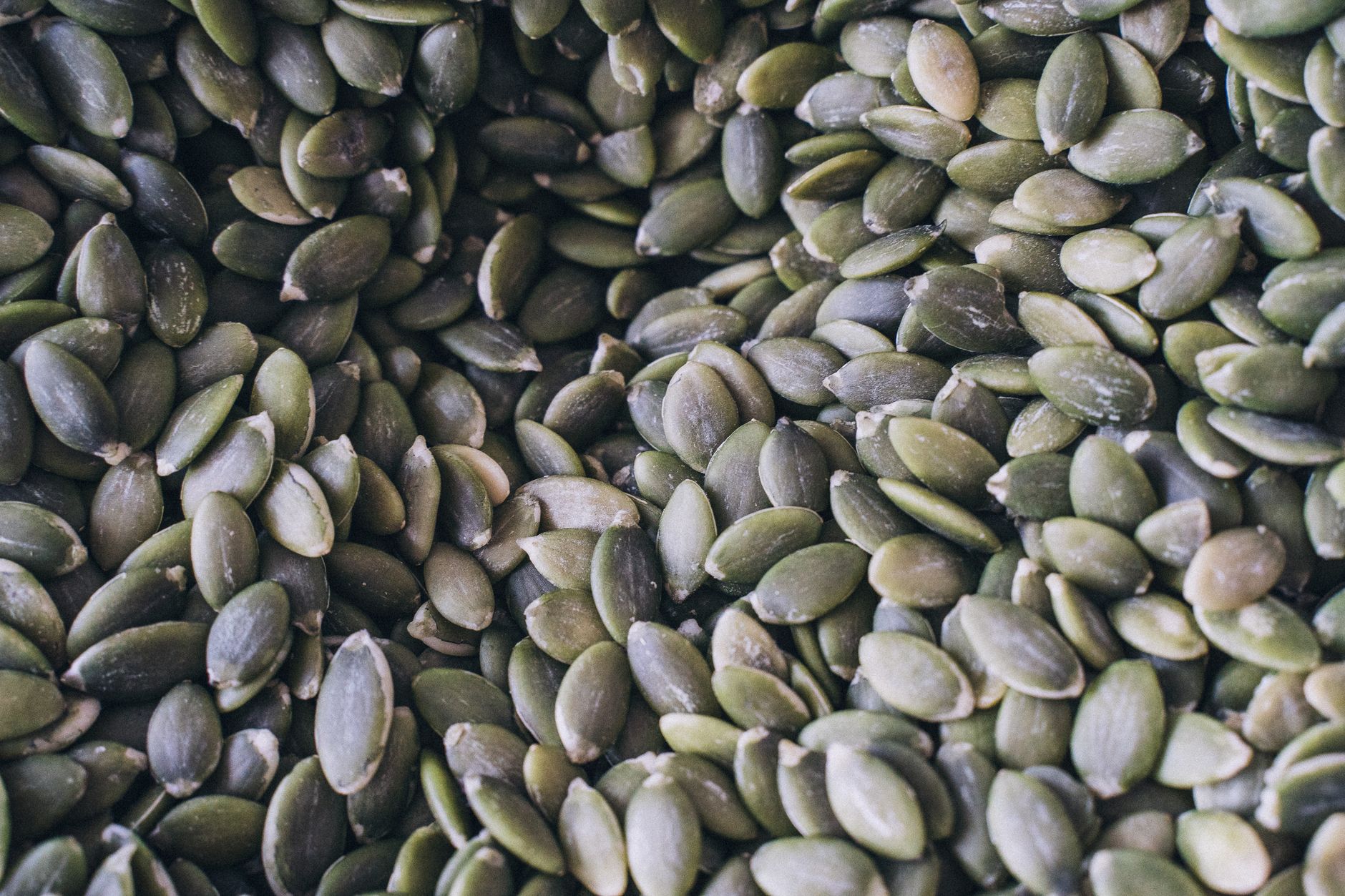 A close-up shot of organic pumpkin seeds showcasing their natural texture and green hue.