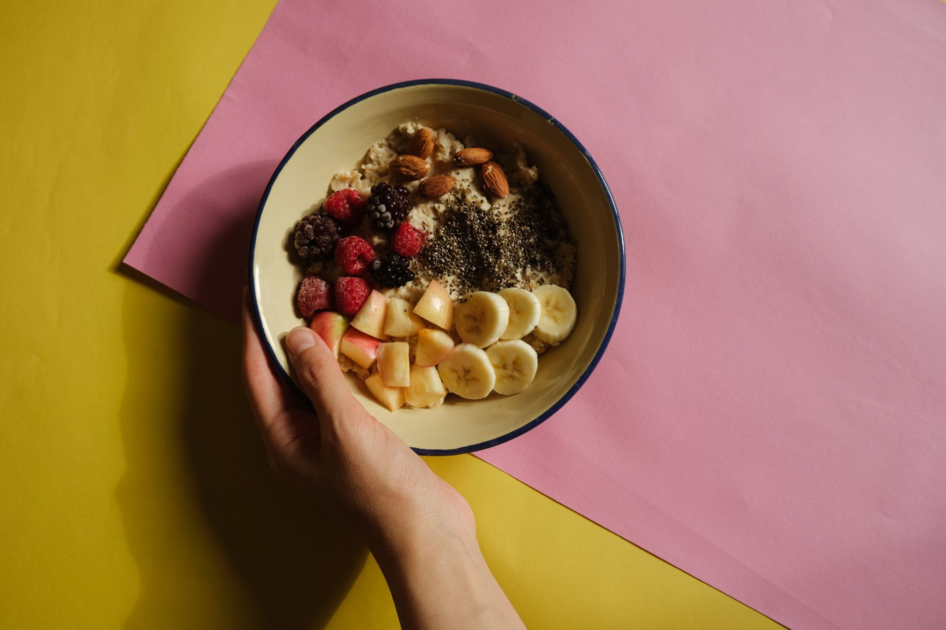 A vibrant oatmeal bowl with fruits and nuts on a pastel background, perfect for healthy breakfast ideas.